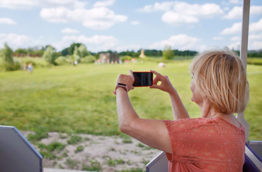 A senior takes a picture of the view while touring a senior living community to help decide on their next living space